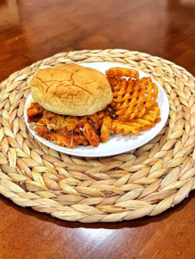 Cheesy BBQ chicken sandwich with melted cheese on a soft bun