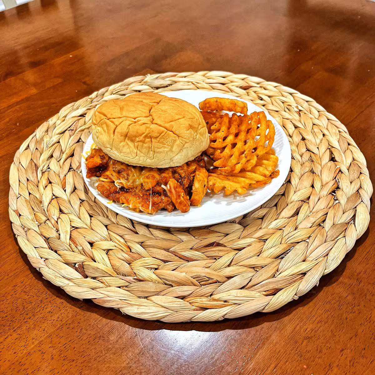 Cheesy BBQ chicken sandwich with melted cheese on a soft bun
