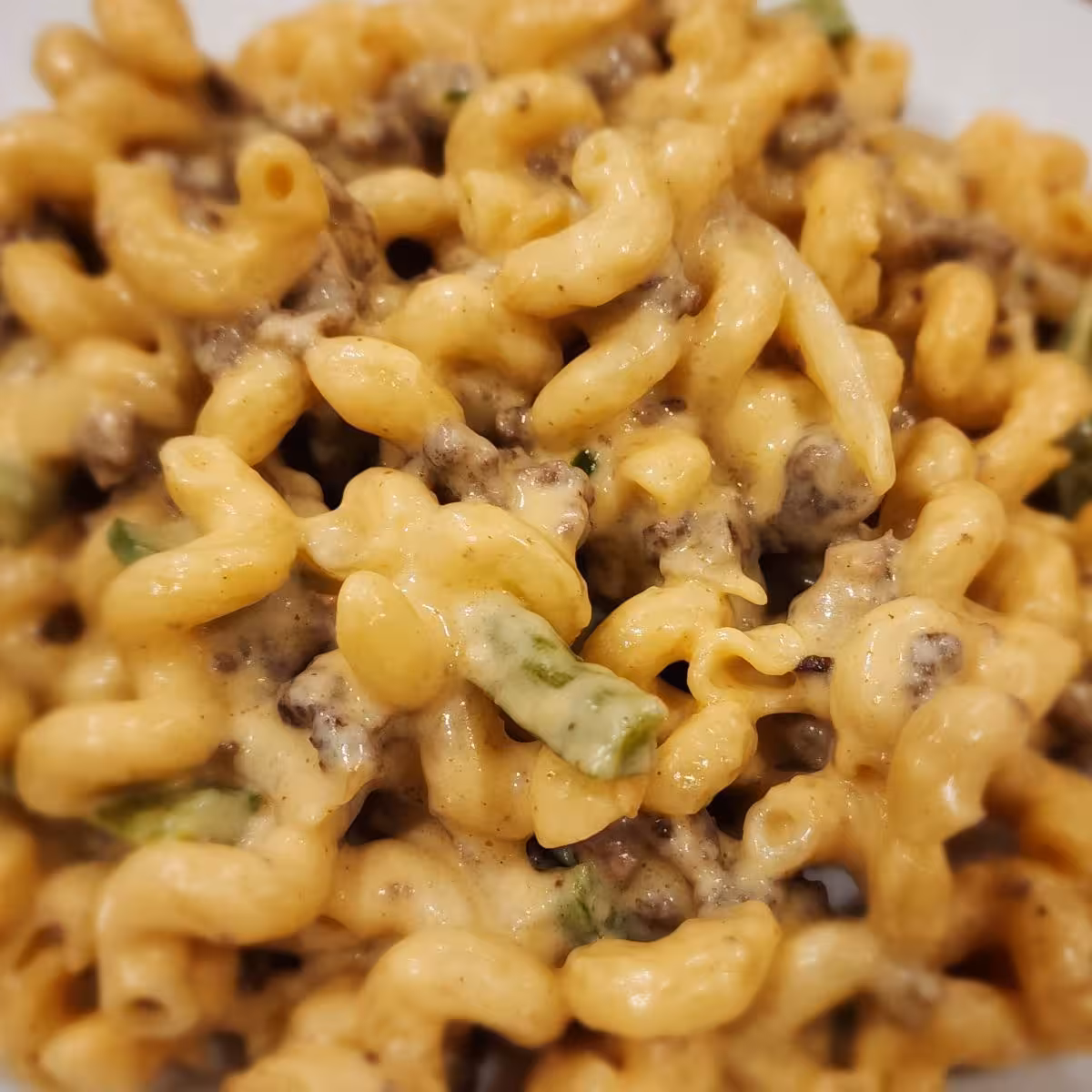 Philly cheesesteak mac and cheese with ground beef, peppers, onions, and creamy cheese sauce