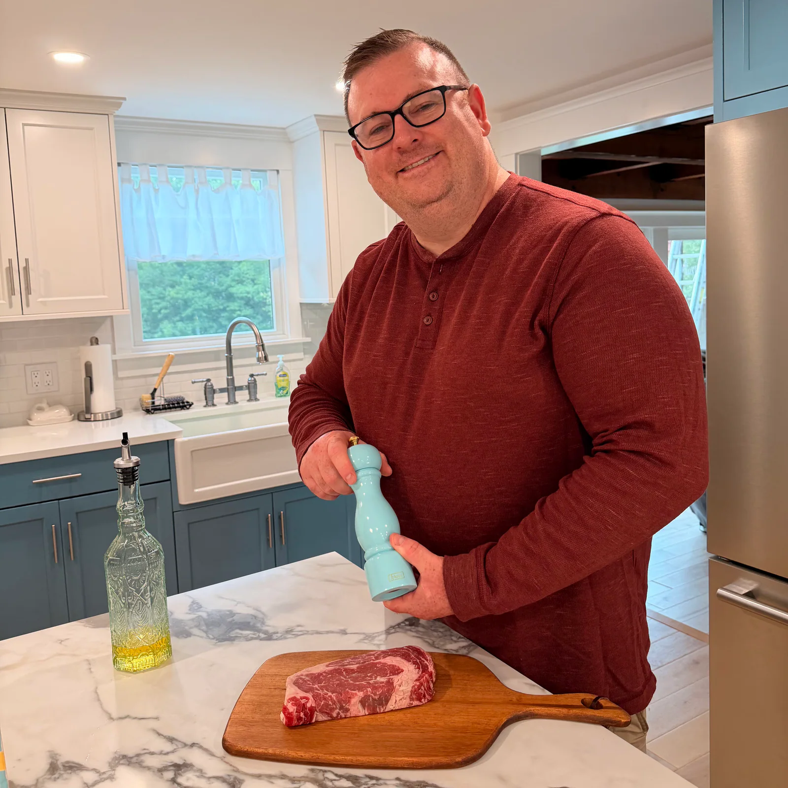 Jeff Murphy seasoning a steak in the Kitchen Affliction kitchen